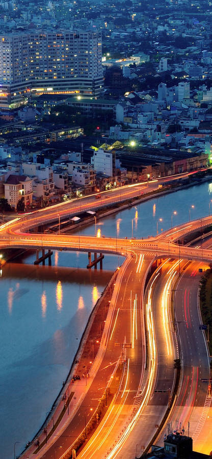 Captivating Ho Chi Minh City At Night With Bustling Traffic Wallpaper
