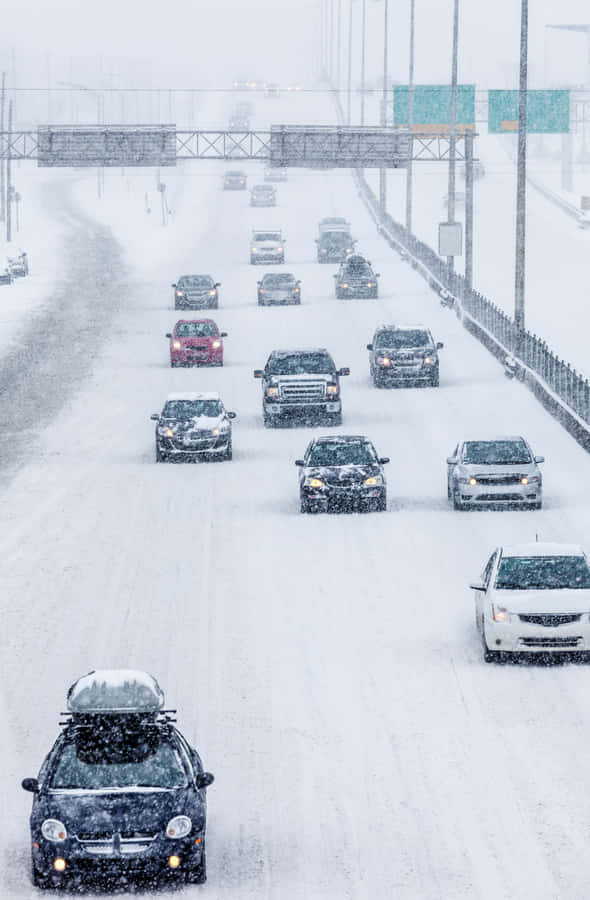 Car Driving Through A Snowy Landscape During Winter Wallpaper