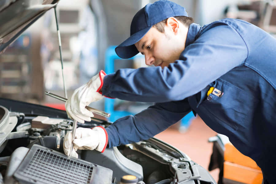 Car Mechanic Working Under A Vehicle On Lift Wallpaper