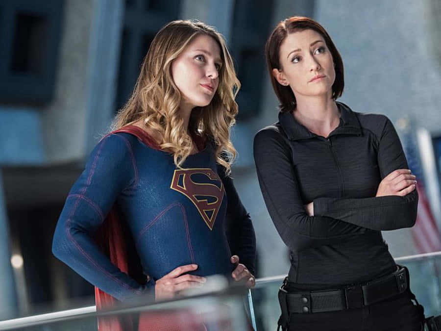 Chyler Leigh Posing Against A Gray Background, Smiling At The Camera Wallpaper