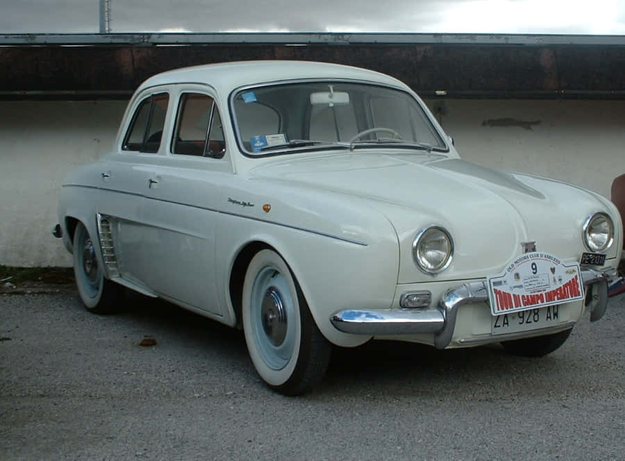 Classic Renault Dauphine Parked In Urban Setting Wallpaper