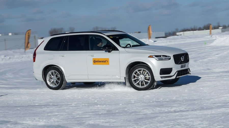 Close-up Of Winter Tires On A Snowy Road Wallpaper