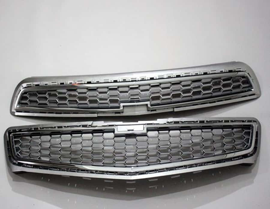 Close-up View Of A Shiny Car Grill On A Modern Vehicle Wallpaper