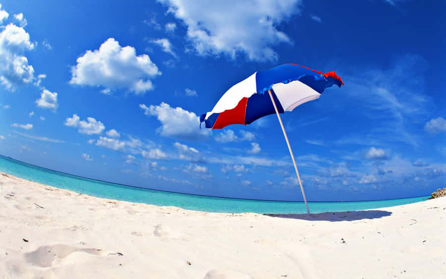 Colorful Beach Umbrella On A Sunny Shoreline Wallpaper