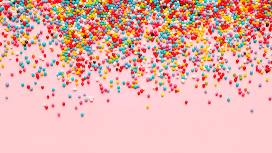 Colorful Sprinkleson Pink Background Wallpaper