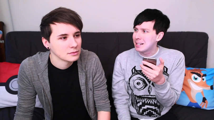 Dan And Phil Sitting On A Couch Wallpaper