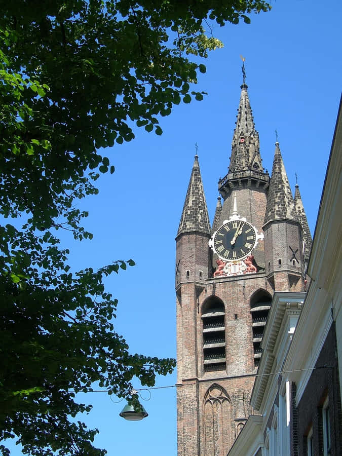 Delft Clock Tower Against Blue Sky Wallpaper
