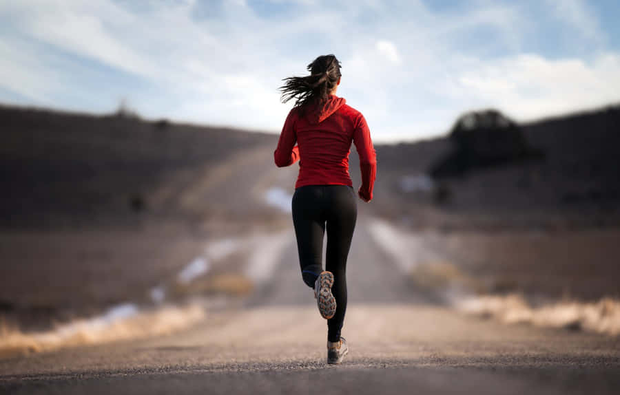 Determined Female Athlete Training For Marathon Wallpaper