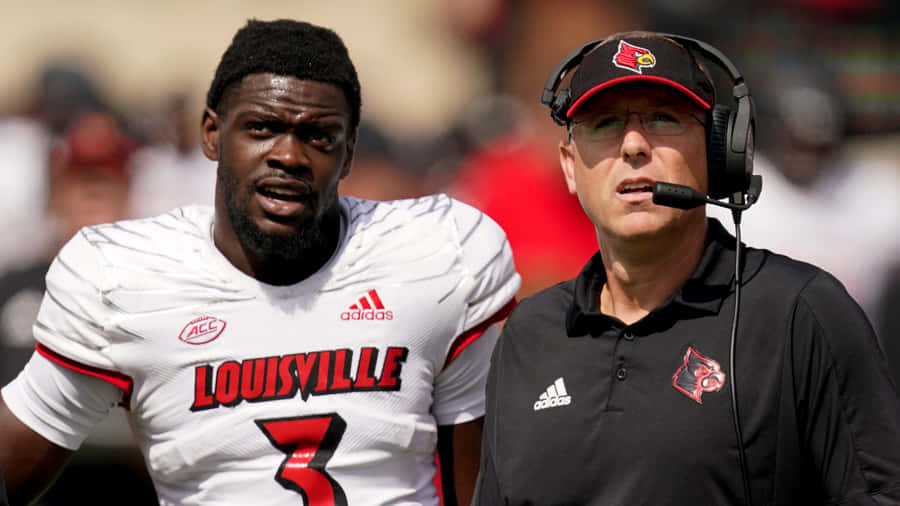 Determined Football Coach Strategizing Play Wallpaper