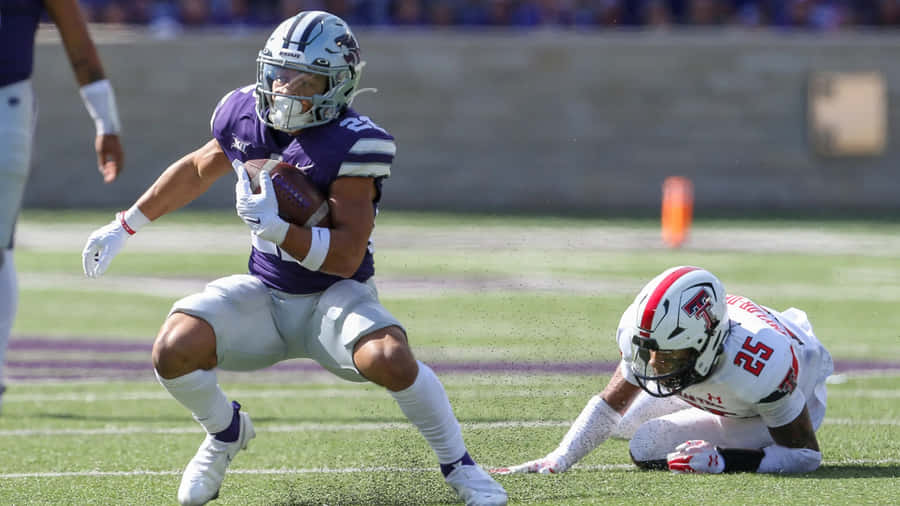 Deuce Vaughn Evading Tackle During Game Wallpaper