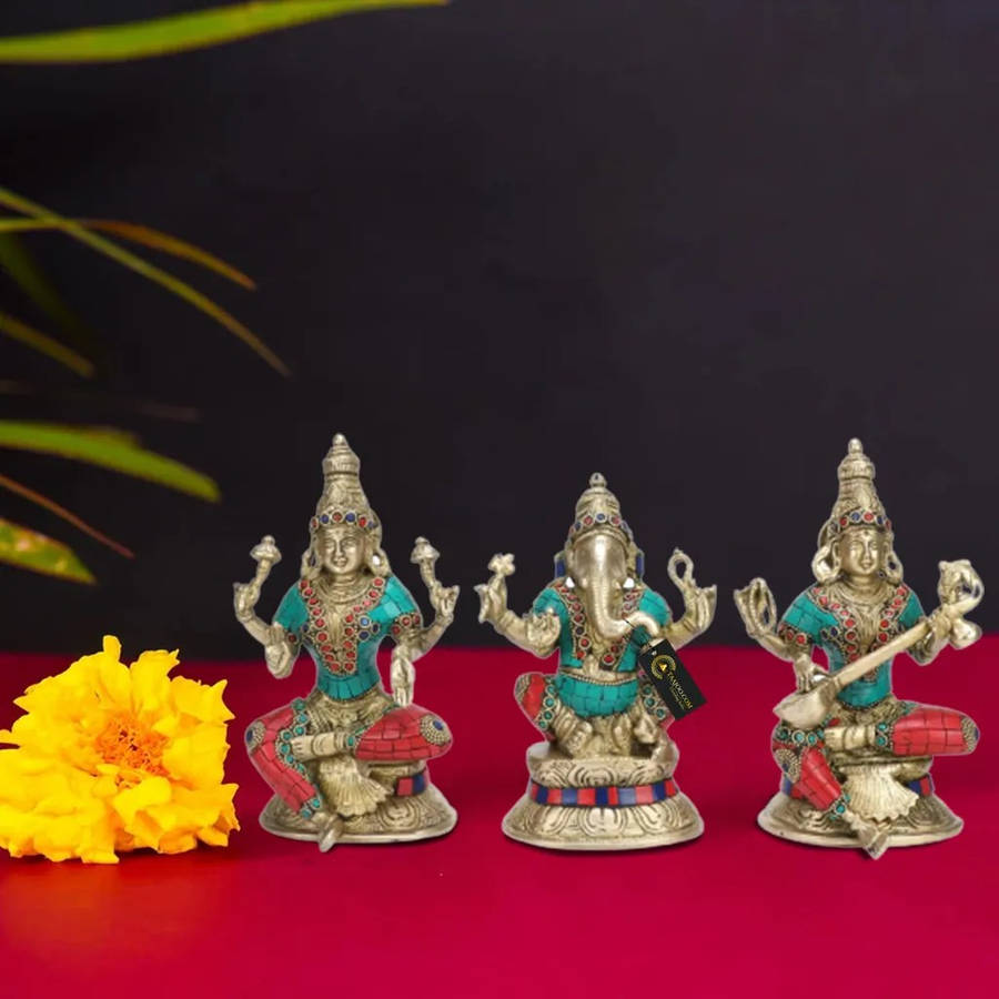 Divine Trio - Silver Figurines Of Laxmi, Ganesh, And Saraswati Wallpaper