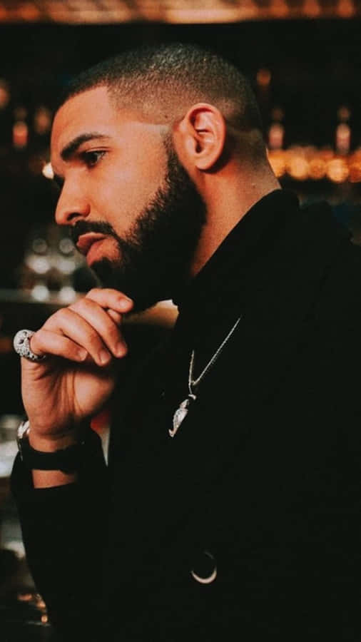 Drake Radiates Golden Vibes On A City Rooftop Wallpaper