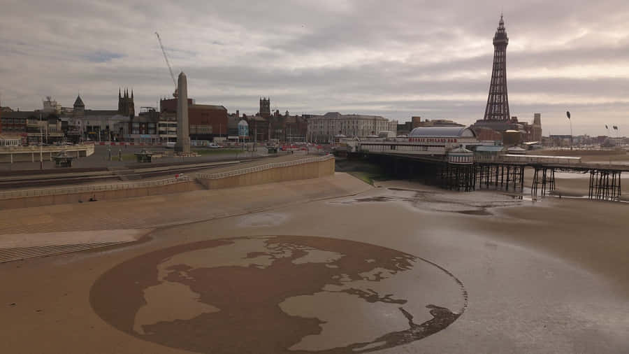 Earth Sculpture In The Sands Near The Iconic Blackpool Tower Wallpaper