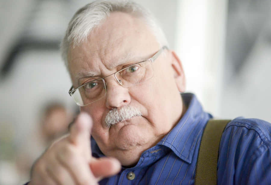 Elderly Man Gesturing With Hand Wallpaper