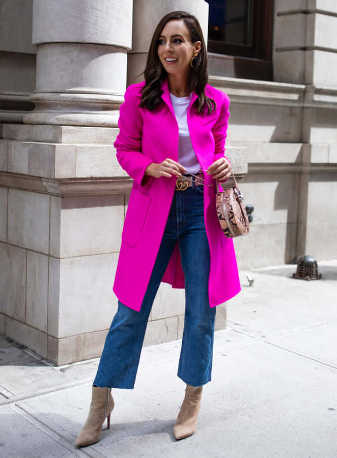Elegance In Fashion - Woman Wearing A Stylish Pink Coat Wallpaper