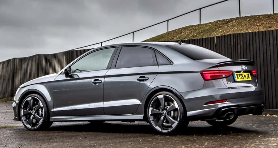 Elegant Sedan Gliding Down The Road Wallpaper