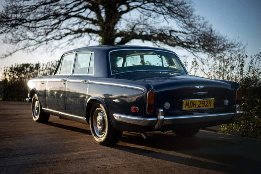 Elegant Vintage Bentley T1 On A Picturesque Ocean Road Wallpaper