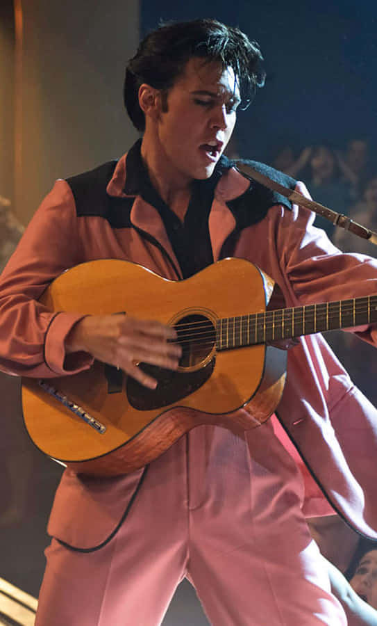 Elvis Presley In Pink Suit Playing Guitar Wallpaper