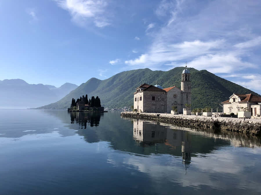 Enchanting View Of Our Lady Of The Rocks Amidst Majestic Mountains Wallpaper