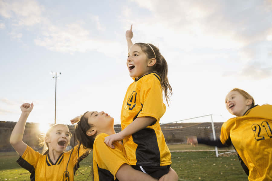 Energetic Kids Enjoying A Soccer Game Wallpaper