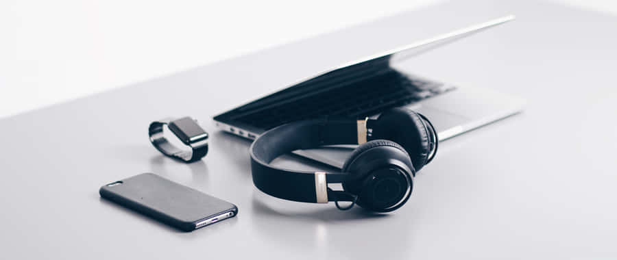 Enjoy Music And Technology With A Laptop And Headphones Wallpaper