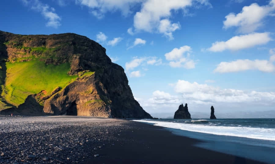 Enjoy The Crystal Clear Views Of The Picturesque Black Sand Beach. Wallpaper