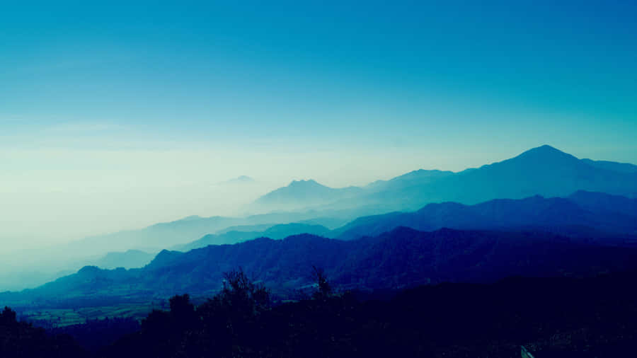 Enjoy The Tranquility Of Blue Mountain Sunrise Wallpaper