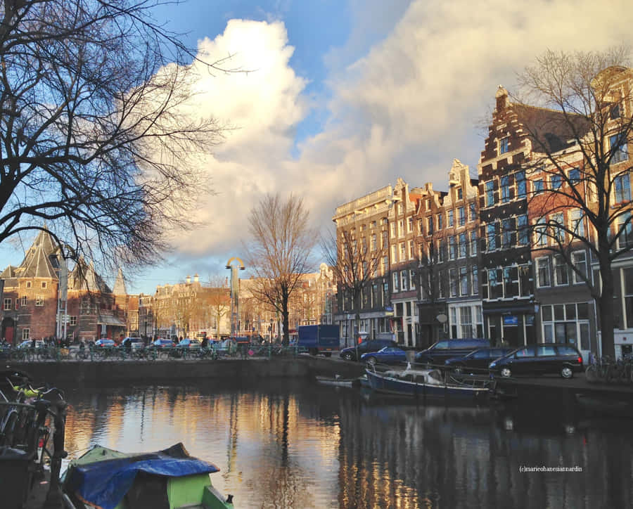 Enjoying A Sunny Spring Day By A Canal In Amsterdam Wallpaper
