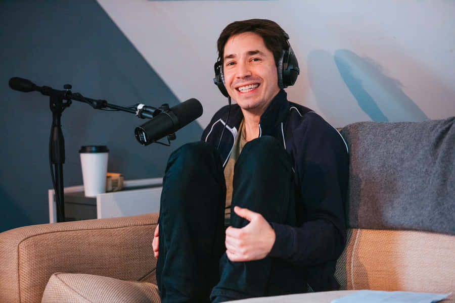 Entertainer Justin Long Smiling During A Photoshoot Wallpaper