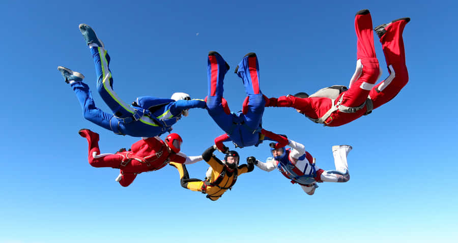 Fearless Adventurer Standing At The Edge Of A Cliff Wallpaper