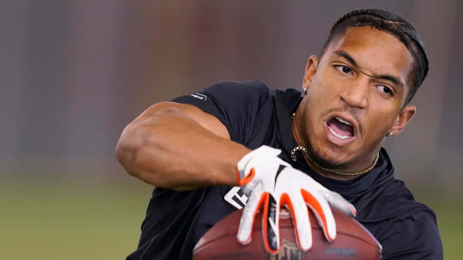 Focused Football Player Catching Ball Wallpaper