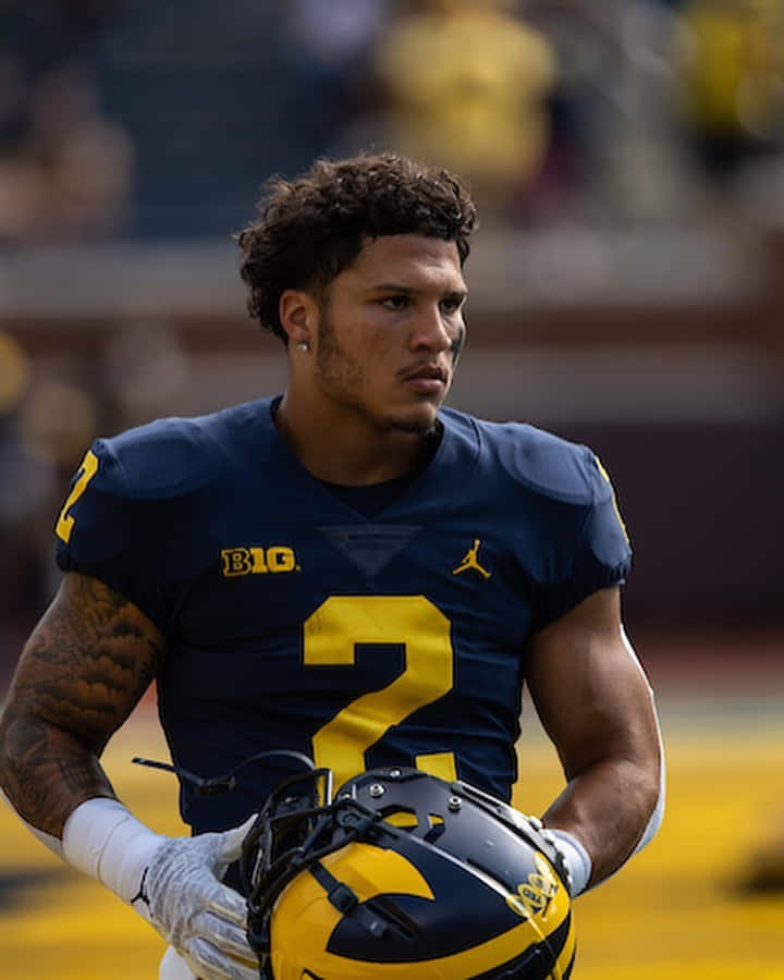 Focused Football Player Holding Helmet Wallpaper