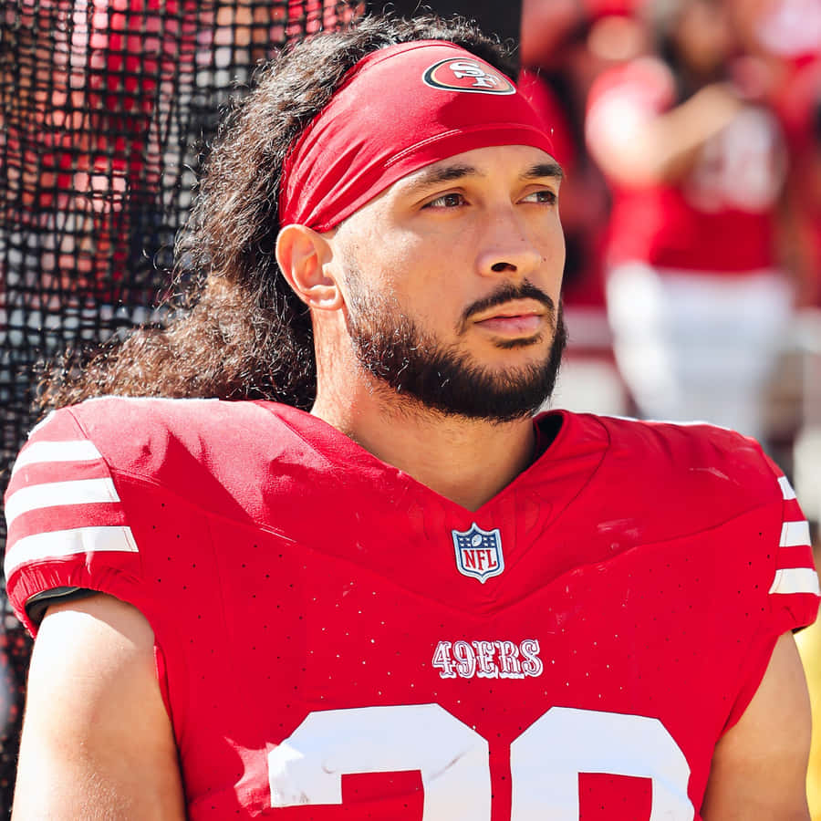 Focused Football Player Red Uniform Wallpaper