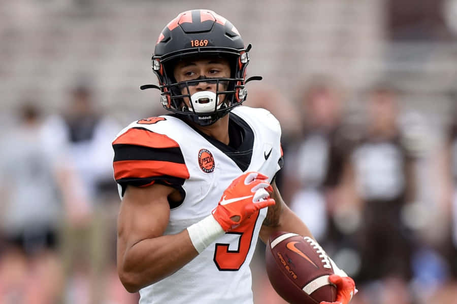 Focused Football Player Running With Ball Wallpaper