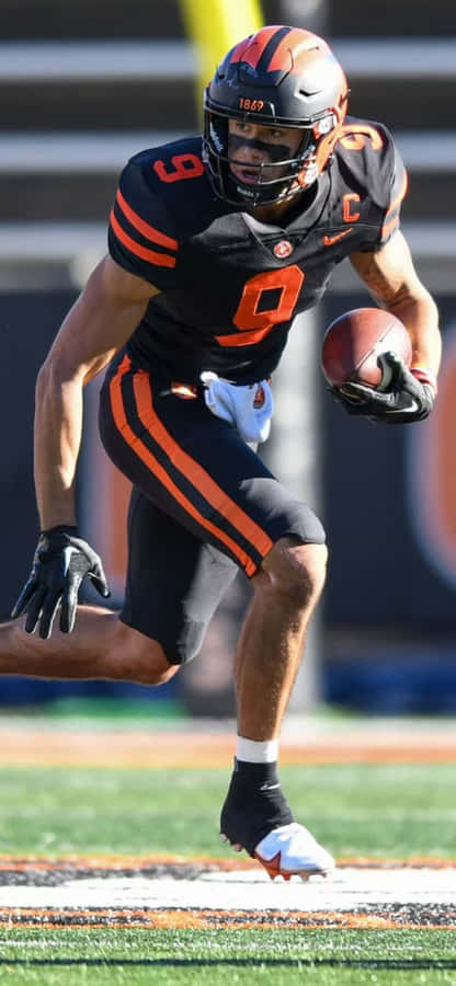 Focused Football Player Running With Ball Wallpaper