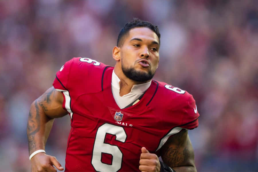 Focused Football Playerin Action Wallpaper