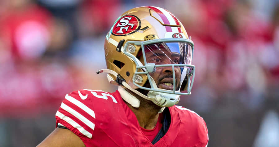 Focused Football Playerin Red Uniform Wallpaper