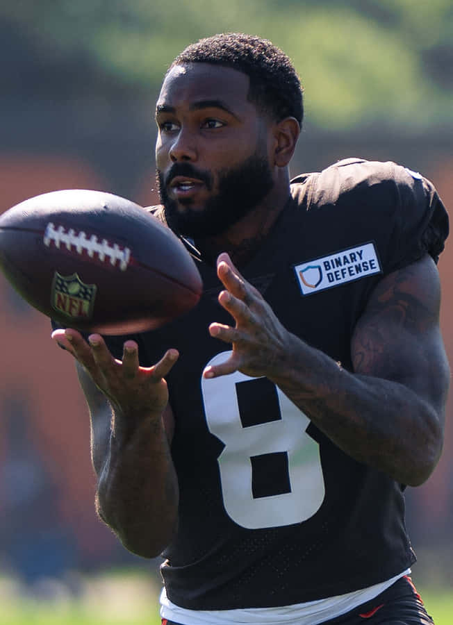 Football Player Catching Ball Practice Session Wallpaper