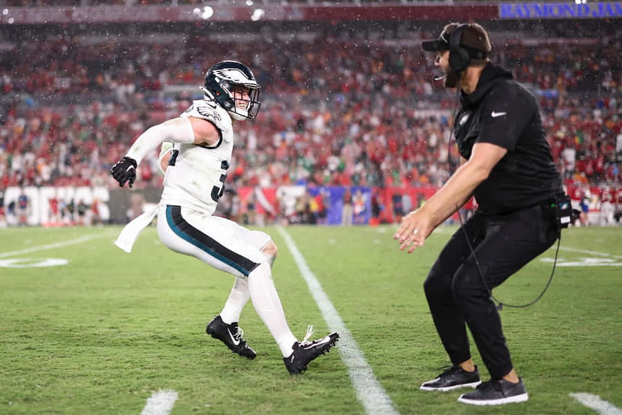 Football Player Celebrationwith Coach Wallpaper