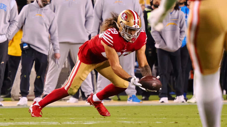 Football Player Fielding Ball During Game Wallpaper