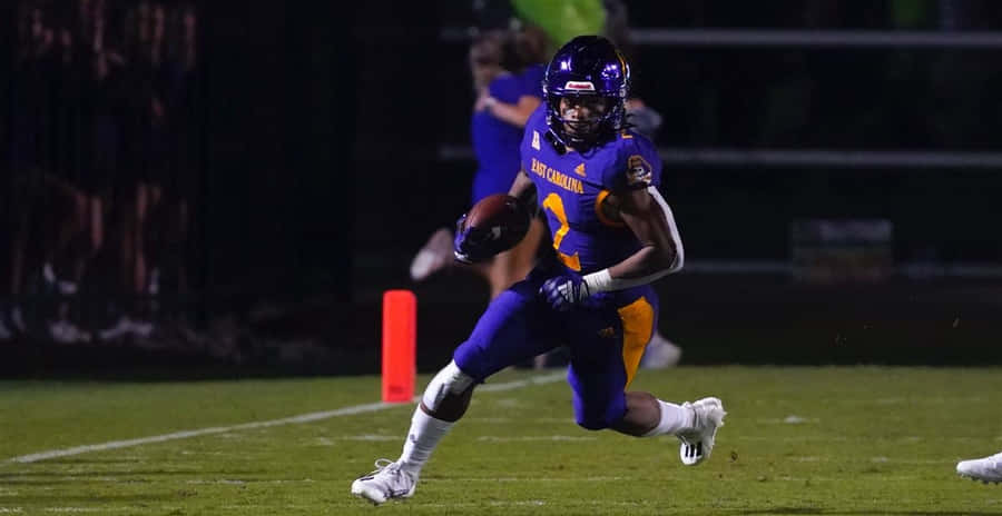 Football Player In Action During Night Game.jpg Wallpaper