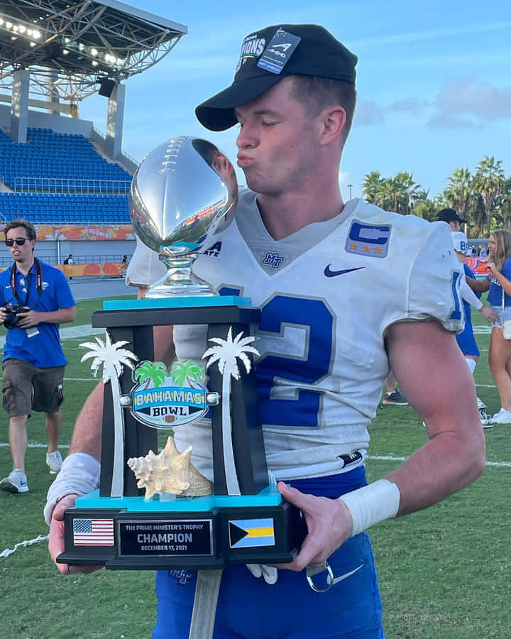 Football Player Kissing Trophy Bahamas Bowl Wallpaper