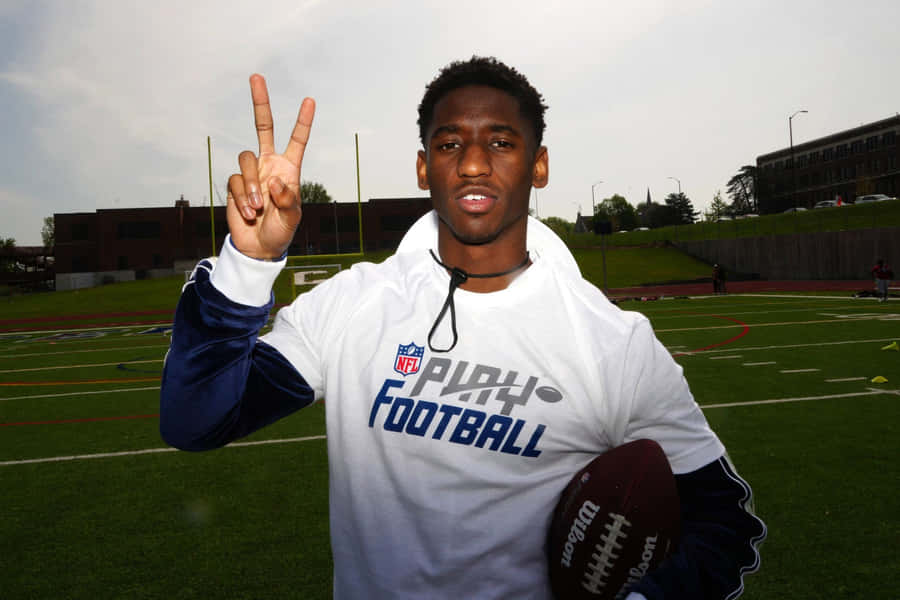 Football Player Peace Signon Field Wallpaper