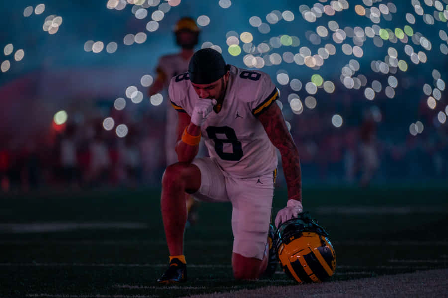 Football Player Reflective Moment Wallpaper