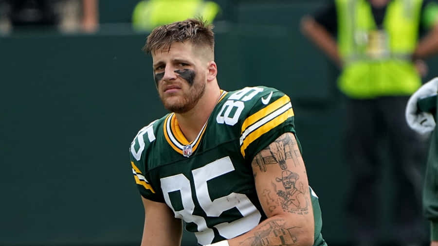 Football Player Sideline Contemplation Wallpaper