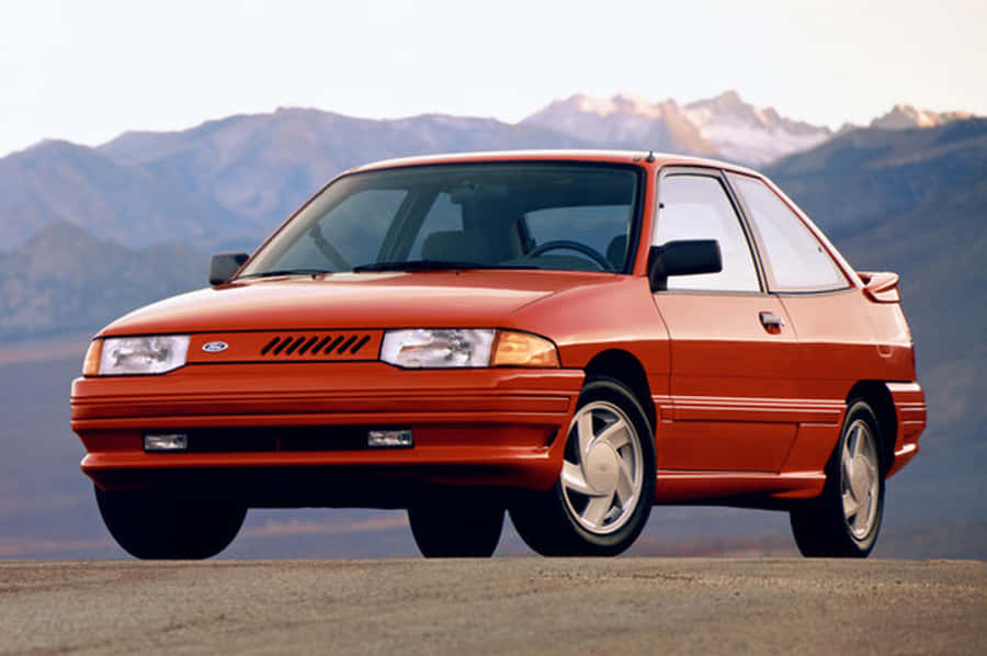 Ford Escort Classic On Scenic Road Wallpaper