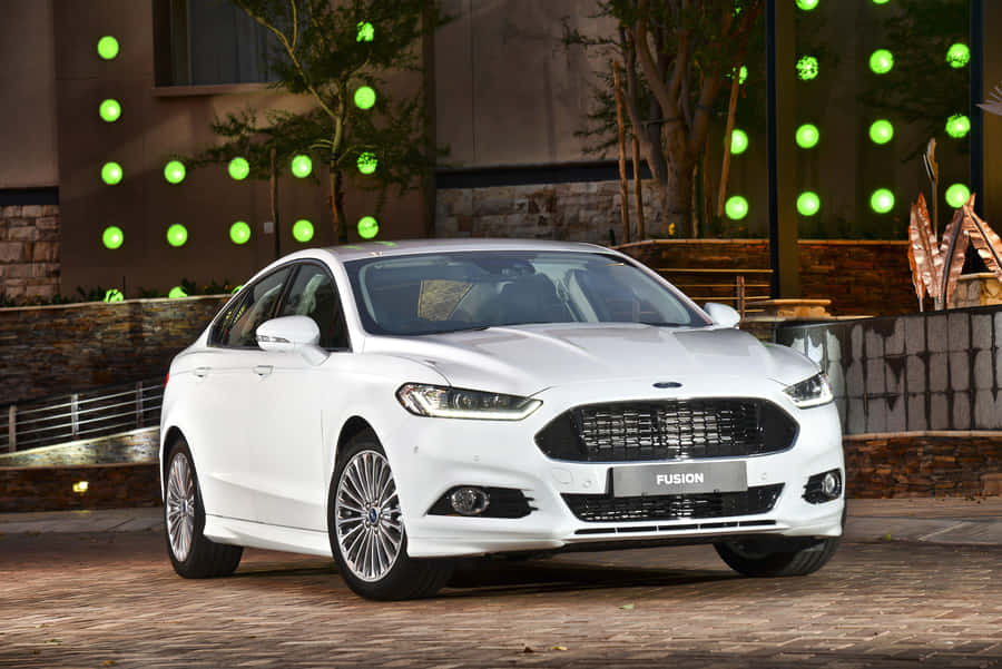 Ford Fusion Cruising On A Scenic Route Amidst Pristine Nature Wallpaper