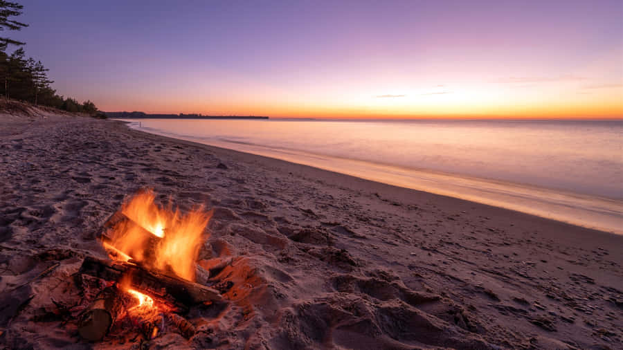 Friends Enjoying A Fall Bonfire Wallpaper