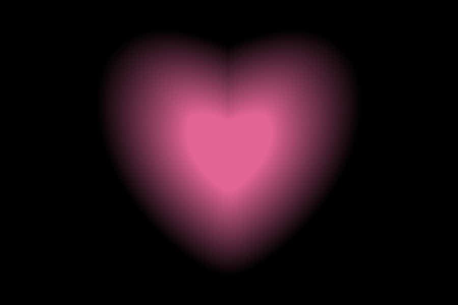 Glowing Heart Against Black Background Wallpaper