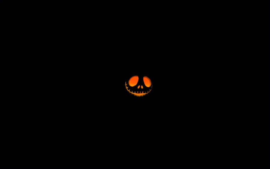 Glowing Jack O Lantern Faceon Black Background Wallpaper